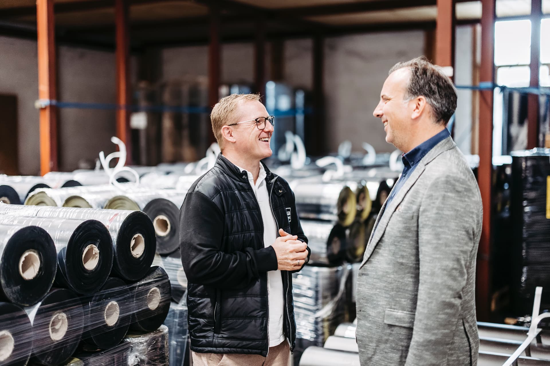 Jochen Köb von KOEB Finanz im Gespräch mit einem Vertreter von Amann in der Lagerhalle in Hard
